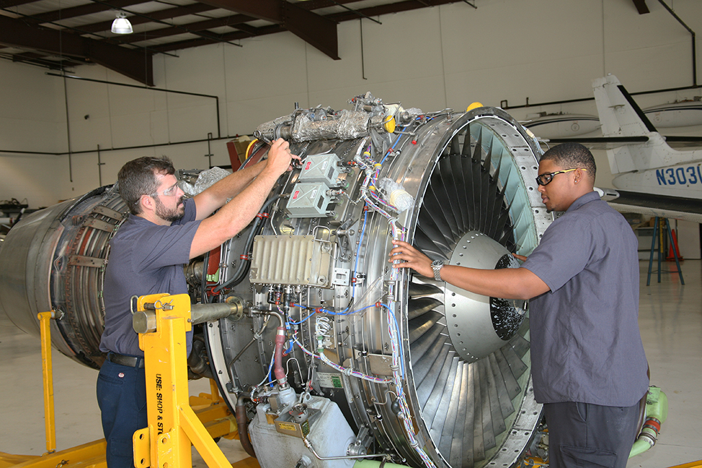 Drew Ware (left) of Cave Spring and Lawrence Peters (right) of Austell work on the CFM56-3B1 high-bypass turbofan engine that was donated to GNTC by Southwest Airlines.