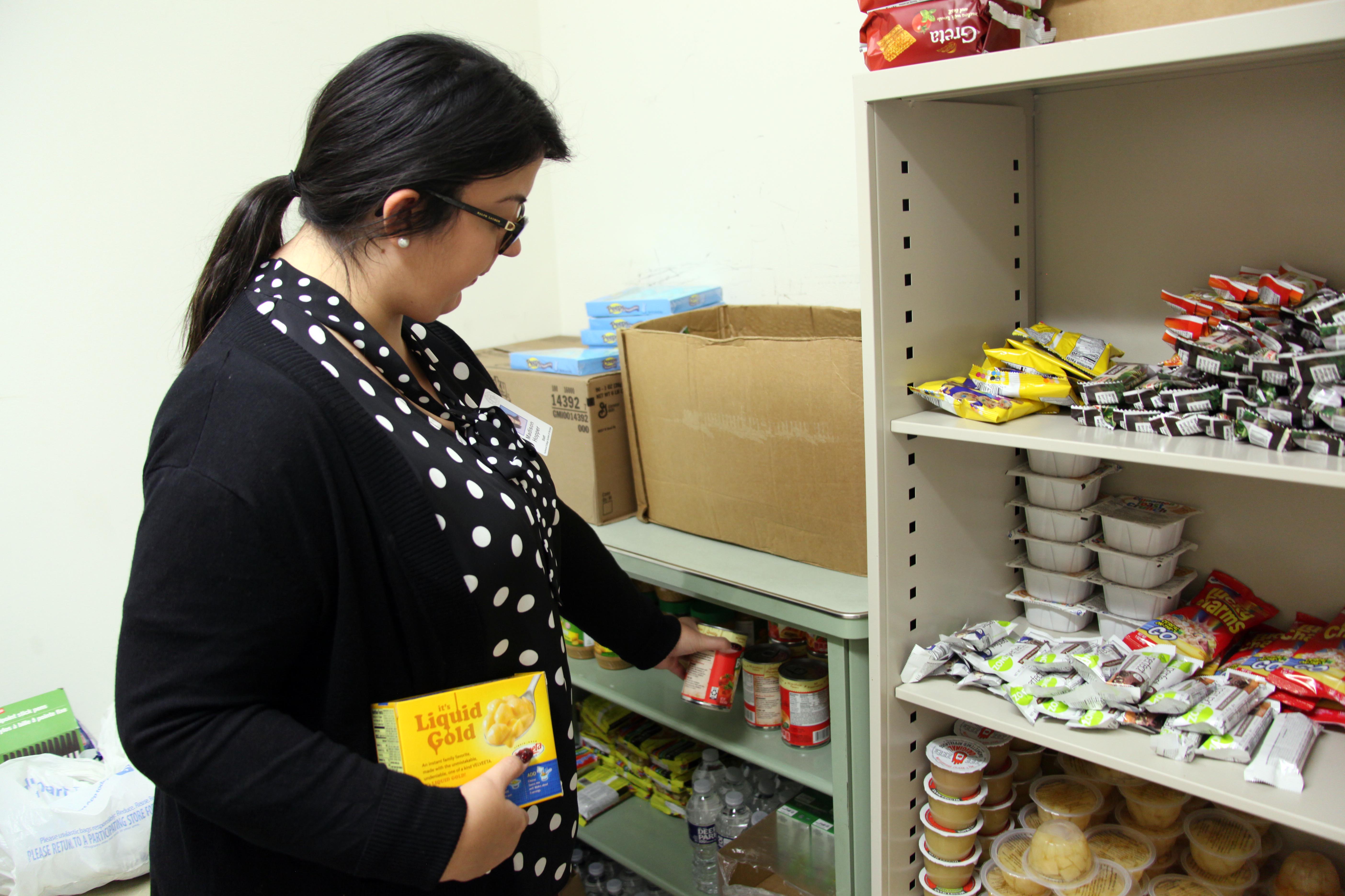 Special Populations Assistant Madison Hopper stocks one of the shelves in the GNTC Food Pantry on the Floyd County Campus.  