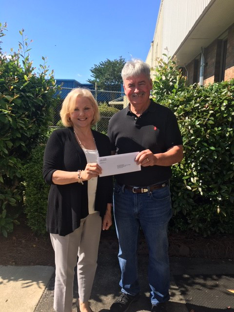 Spunkey Mitchell (right), operations manager for OMNOVA Solutions, presents a check for $1,000 to Michelle Beatson (left), foundation administrator for GNTC.