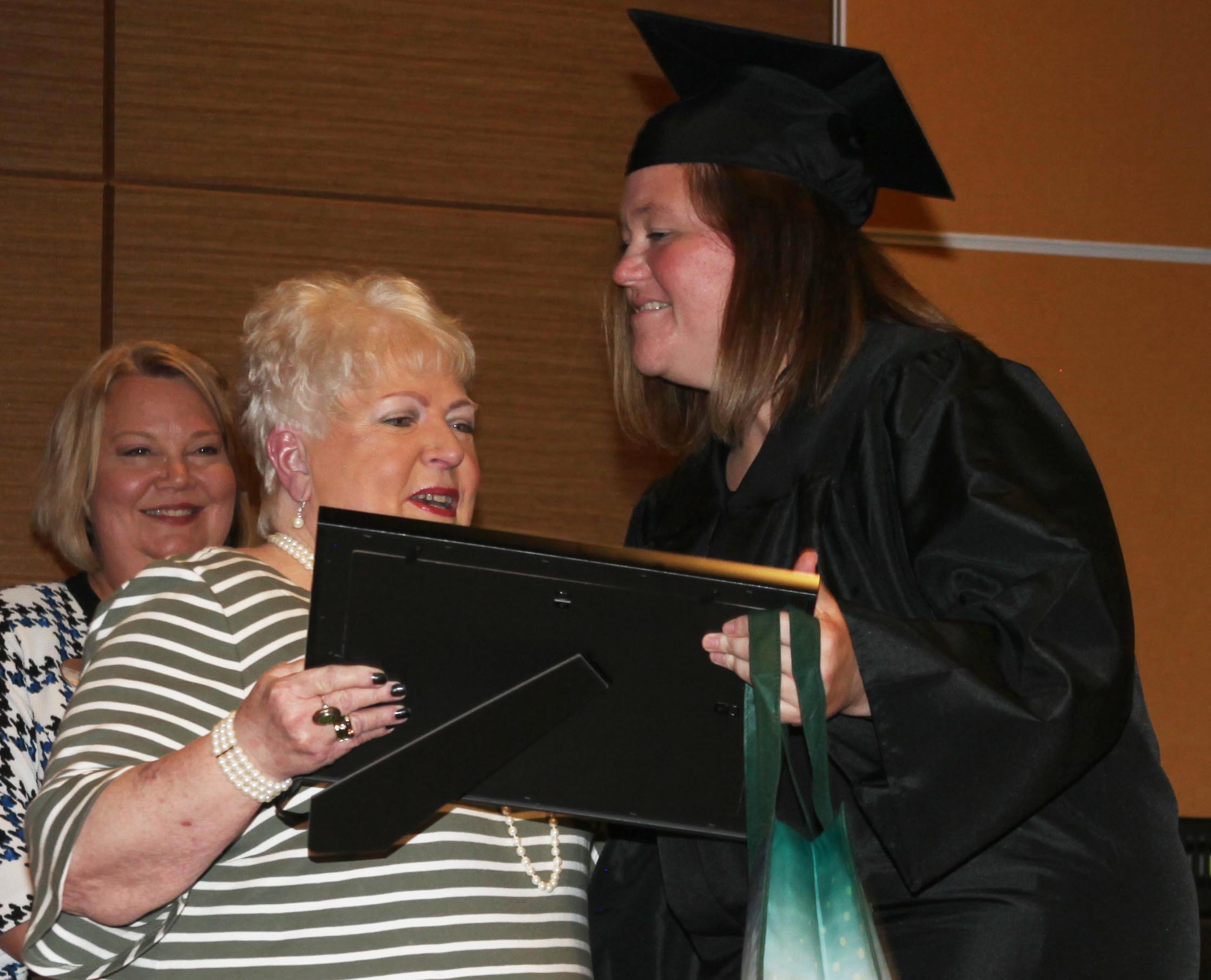 Adult Education instructor Deborah Hester presents Natasha Brown (right) with a $500 scholarship from the Catoosa Citizens for Literacy as Lisa Shaw, GNTC vice president of Adult Education, looks on.