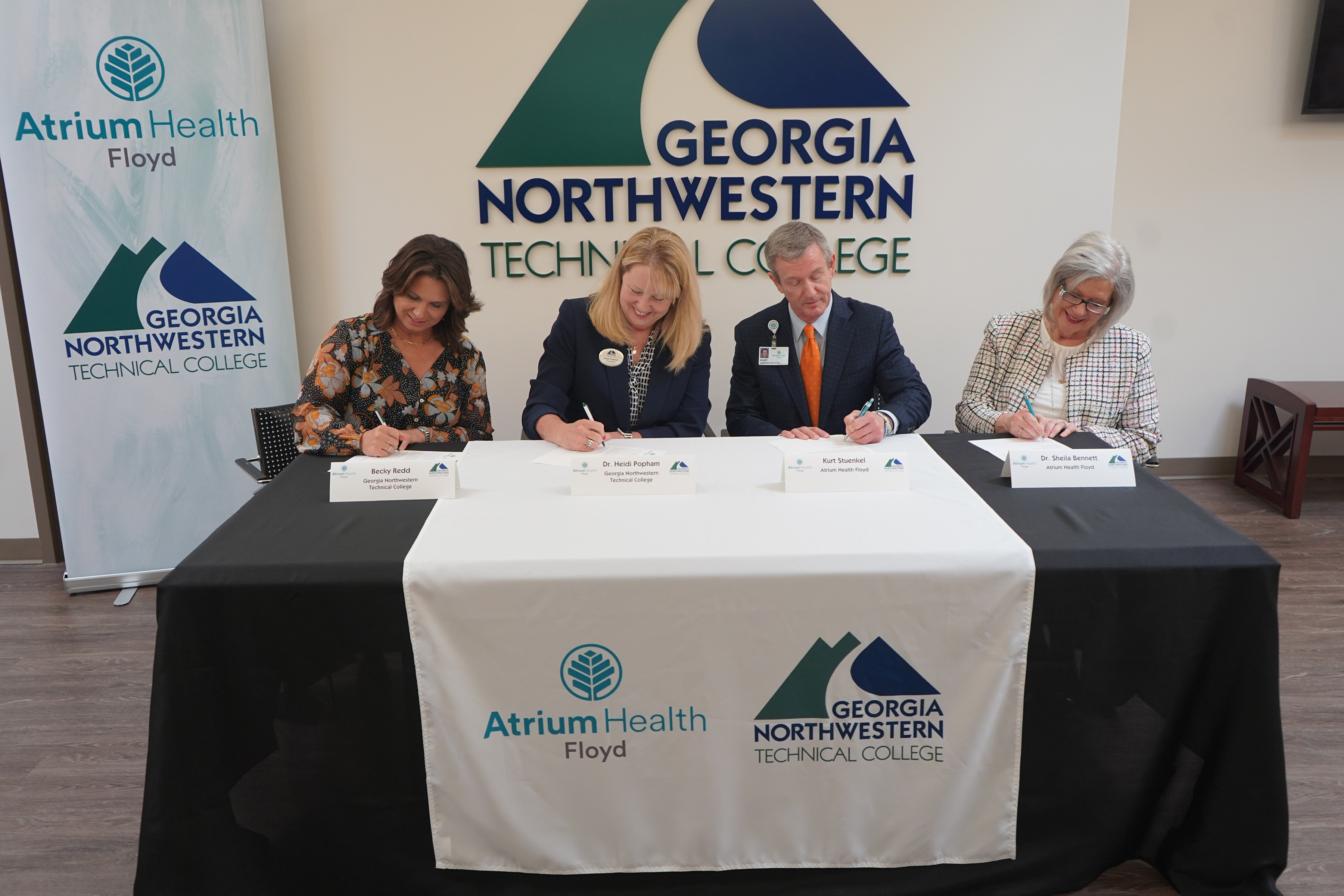 (From left) Becky Redd, GNTC Foundation chair; Dr. Heidi Popham, GNTC president; Kurt Stuenkel, Atrium Health Floyd president; and Dr. Sheila Bennett, Atrium Health Floyd senior vice president and chief of patient services, sign a new agreement designed to boost enrollment in three of GNTC’s healthcare programs and increase the number of Respiratory Therapists, Radiologic Technologists and Certified Nursing Assistants in the northwest Georgia region.
