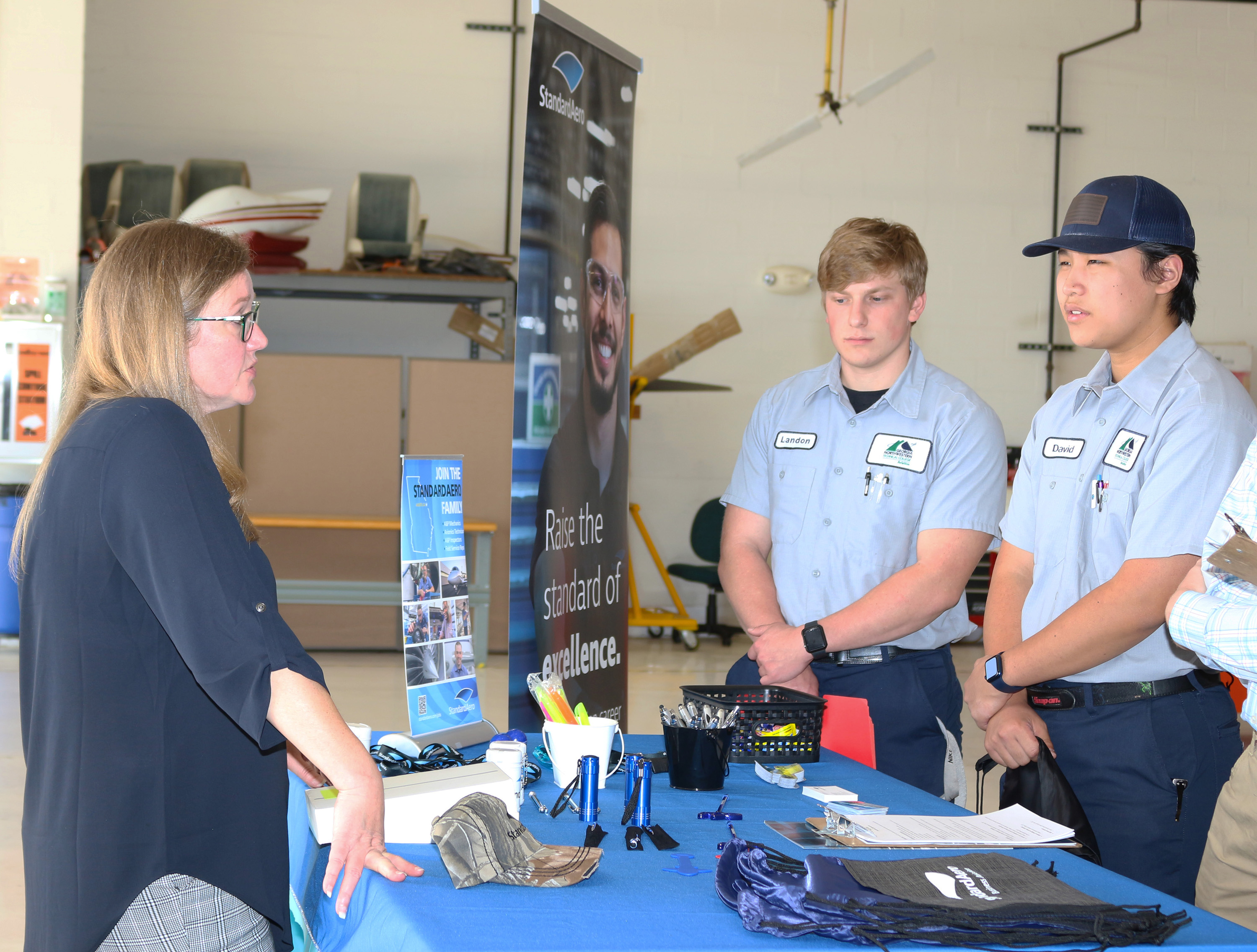 (From left) Jessica Rivers, senior manager of Human Resources with StandardAero, speaks with GNTC students Landon Etzler and David Chen.