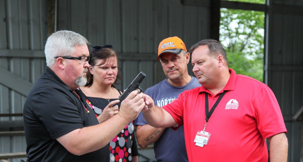 Georgia Northwestern Technical College Law Enforcement Academy Director Jim Pledger, left, displays some of the gun safety procedures his students learn during his program. From left are, Pledger, French Police Officer Lydie Stempfle, French Police Officer Alain Stempfle, and Georgia Northwestern Technical College staffer Fabrice Sainton.