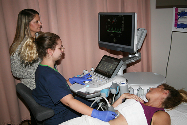 Crista Resch (left) clinical coordinator at GNTC, helps Justine Nichols (center) of Cartersville work with the new Siemens Healthineers S200 Ultrasound Machine while Jodi Lewis (right) of Atlanta plays the part of a patient. Both Nichols and Lewis are Diagnostic Medical Sonography majors at GNTC.