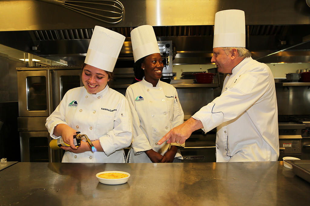 Chef Greg Paulson (right), director of GNTC's Culinary Arts program, oversees students preparing desserts at the Woodlee Culinary Arts facility.