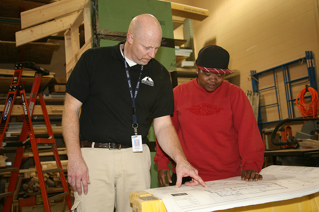 Donny Holmes (left), director of GNTC's Construction Management program looks over blueprints with Diamond Gwynn (right) in the construction lab on GNTC's Gordon County Campus. Like many GNTC instructors, Holmes has found creative ways to teach his students online.