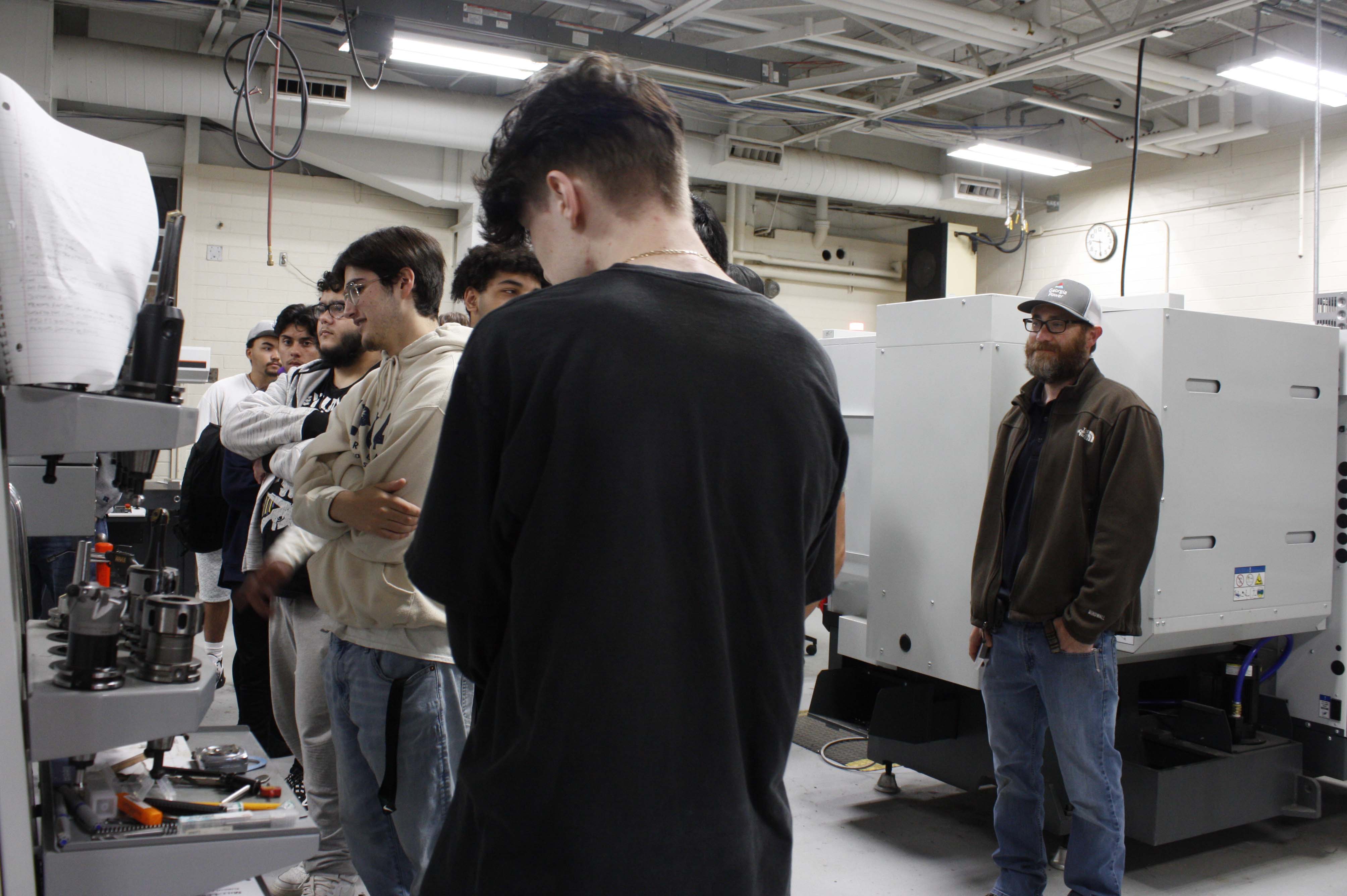 Bart Jenkins (right), program director and instructor of Precision Machining and Manufacturing at GNTC, describes the steps to create a part.