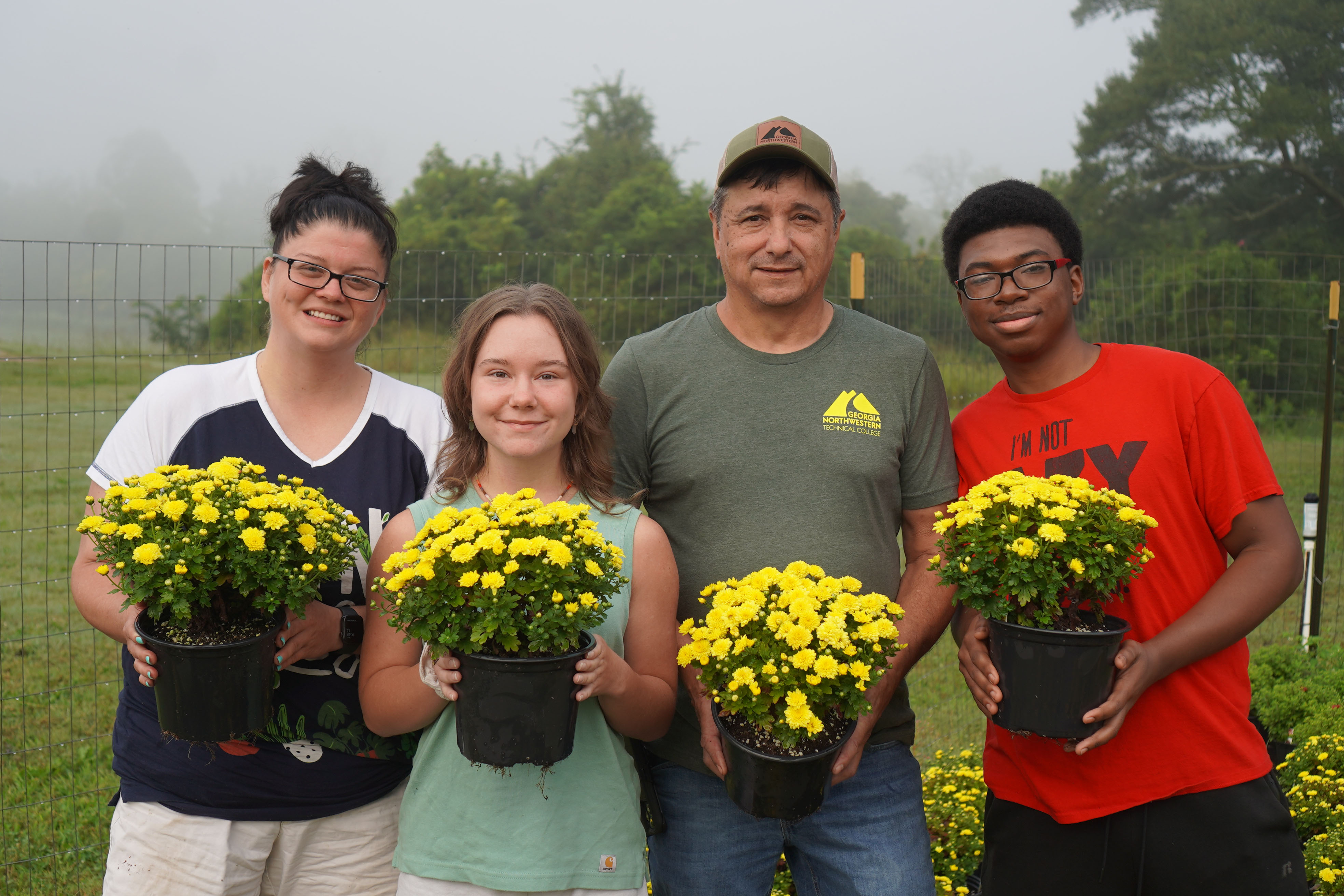 Horticulture students pose with the mums that will be on sale for $4 each at GNTC’s Floyd County Campus starting Sept. 21. (From left to right) Jennifer Clark, of Kingston; Alisha Jackson, of LaFayette; Nick Barton, director of GNTC’s Horticulture program; and Timothy Roberts, of Rome.
