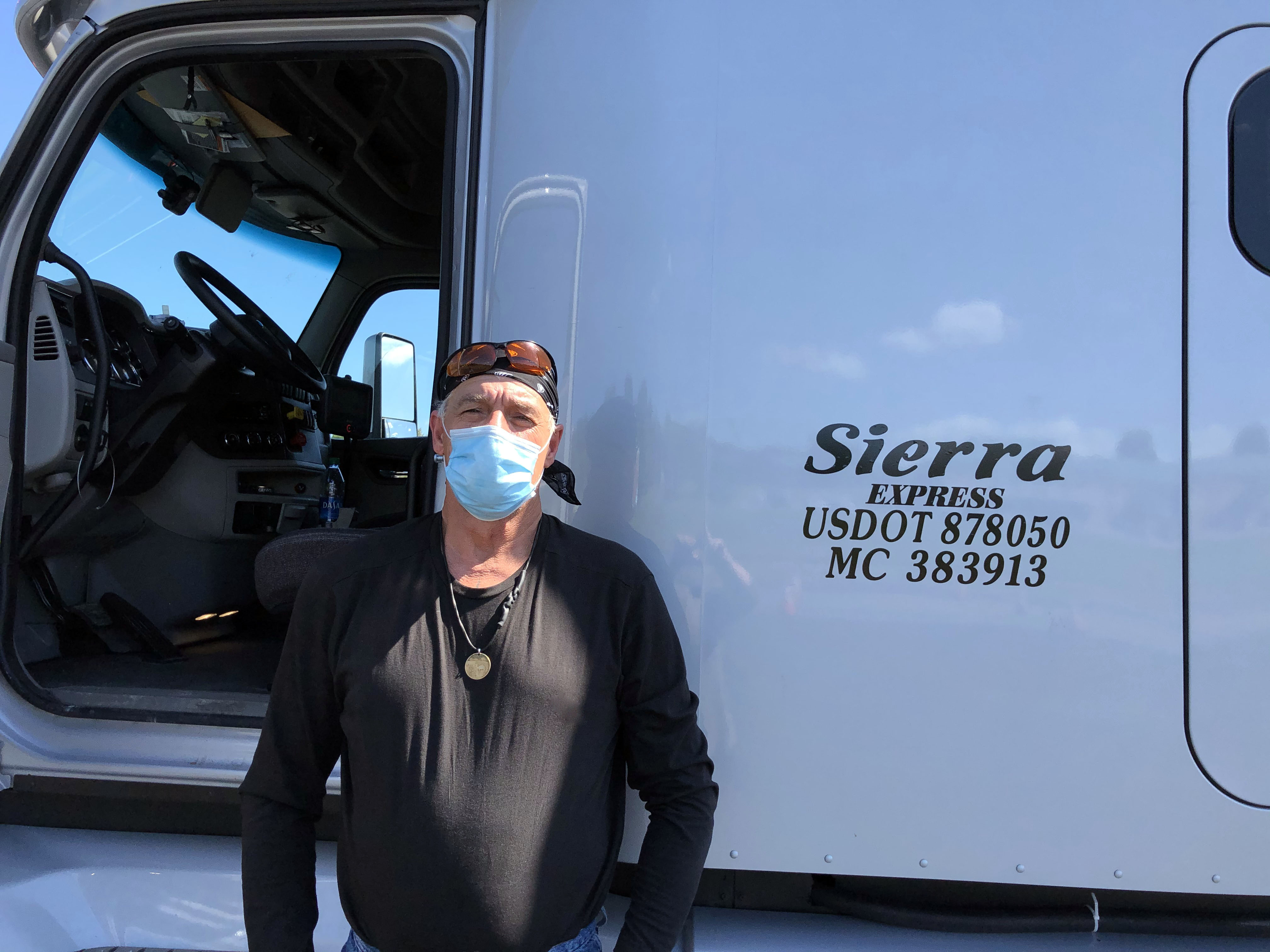 GNTC graduate Jeffery Brown stands next to the new tractor-trailer truck he drives for Sierra Express, Inc. 
