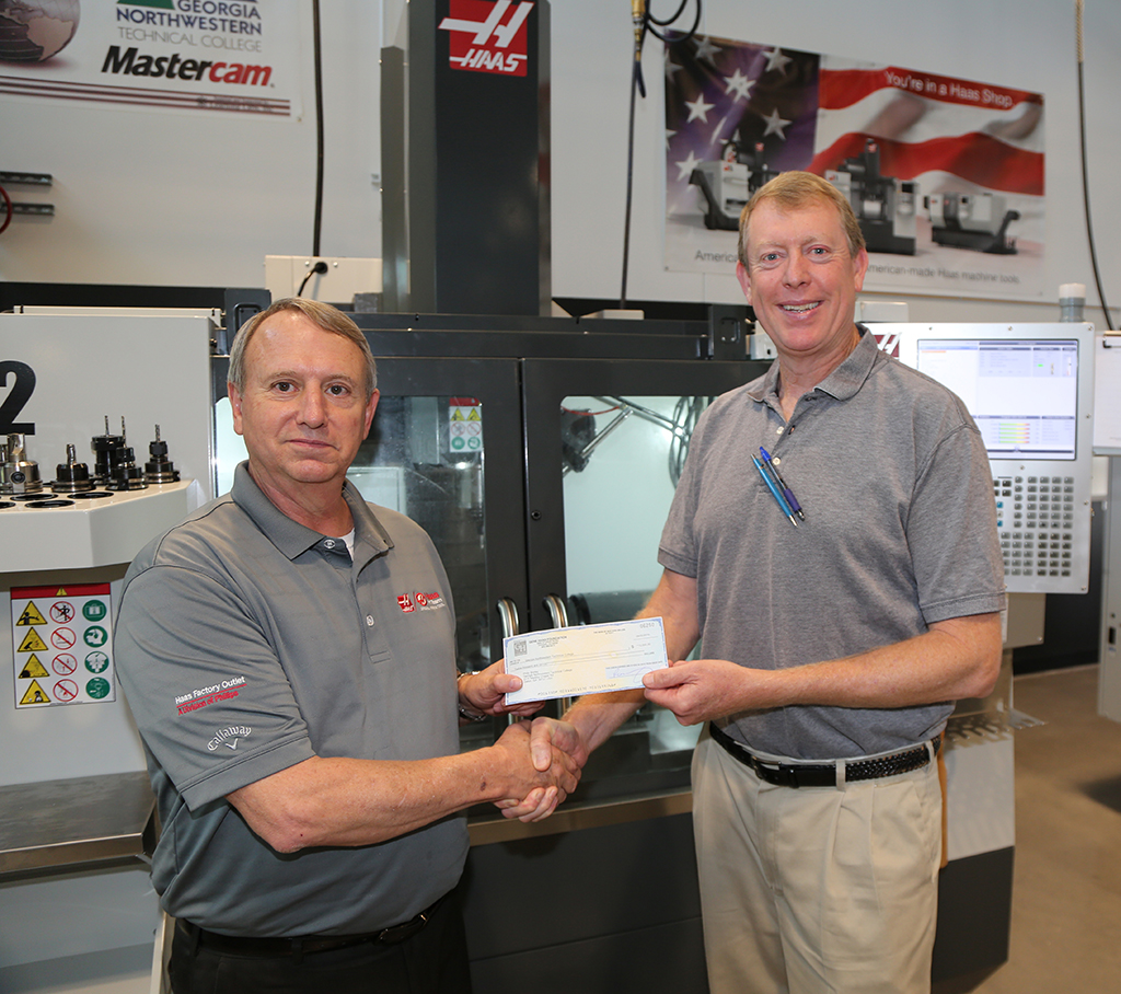 David Aycock (left) presents a check to Philip Shirley for the Precision Machining and Manufacturing program on the Whitfield Murray Campus.