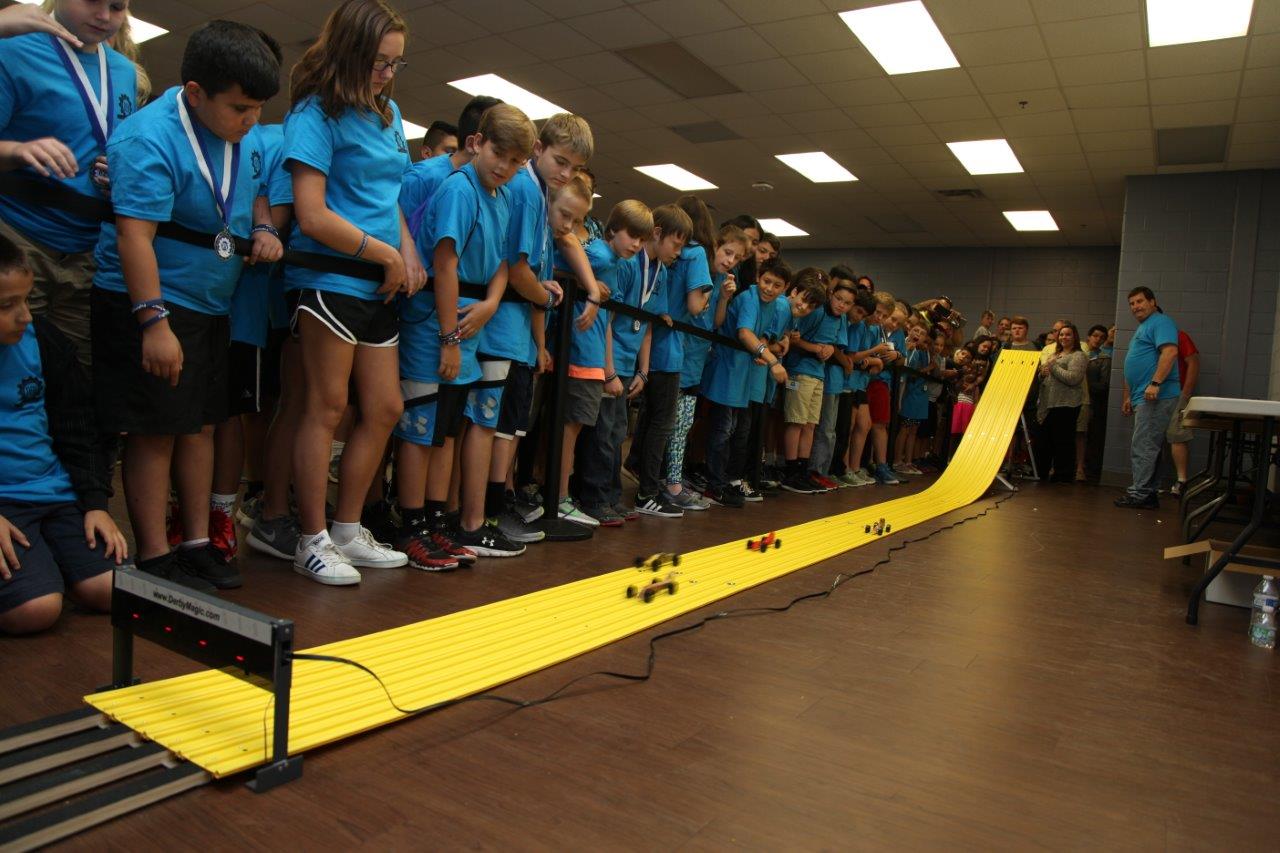 Campers line up to watch one of the many heats of car races June 8 after closing ceremonies in Dalton, Georgia. The cars were designed by campers during the week-long Designing, Engineering, and Manufacturing (DEM) Camp hosted on the campuses of Georgia Northwestern Technical College, Dalton State College, and the Northwest Georgia College & Career Academy.