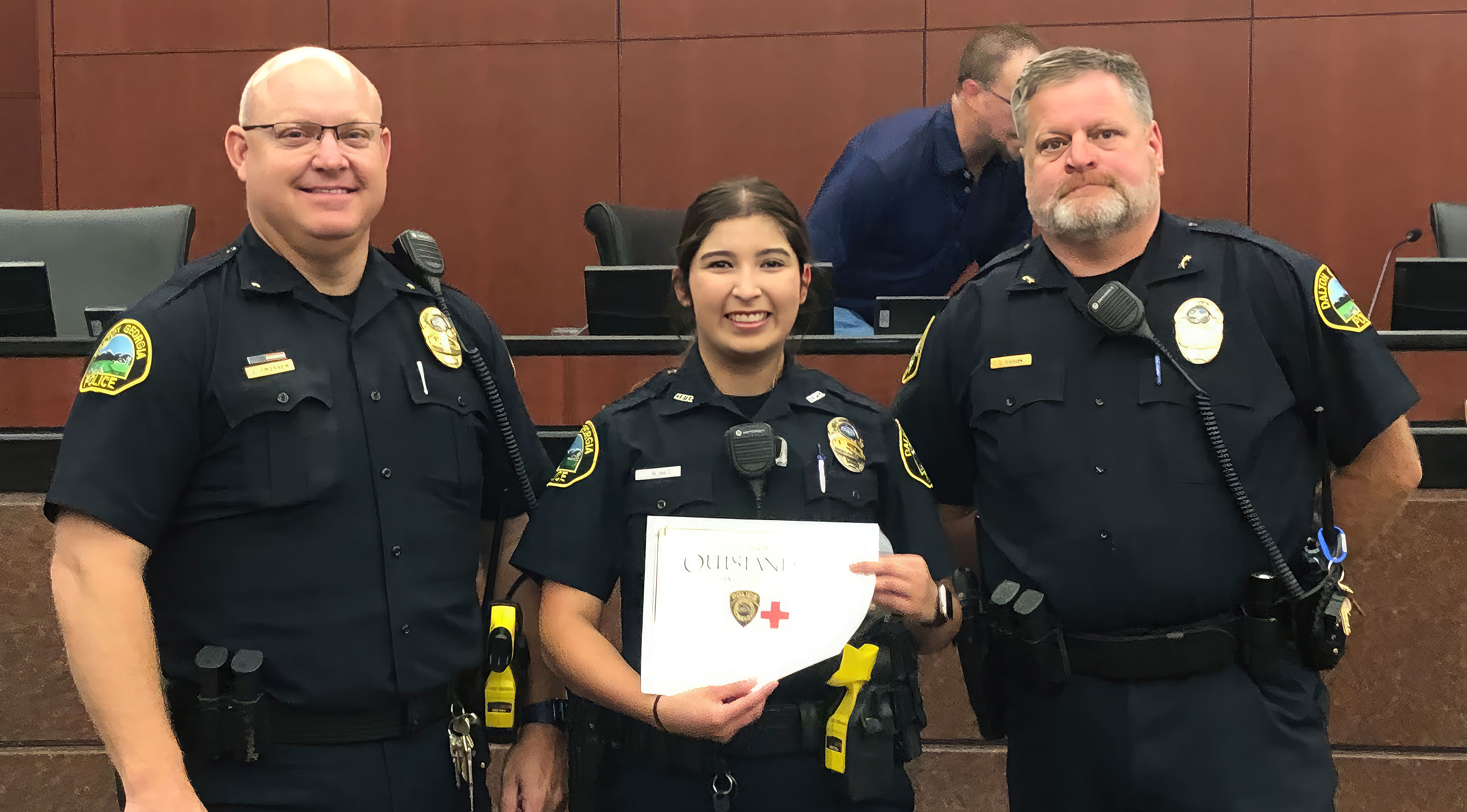 Dalton Police Assistant Chief Chris Crossen (left) and Chief Cliff Cason (right) congratulate GNTC alumna Jennifer Nunez, who received the department’s Life Saver Award. 