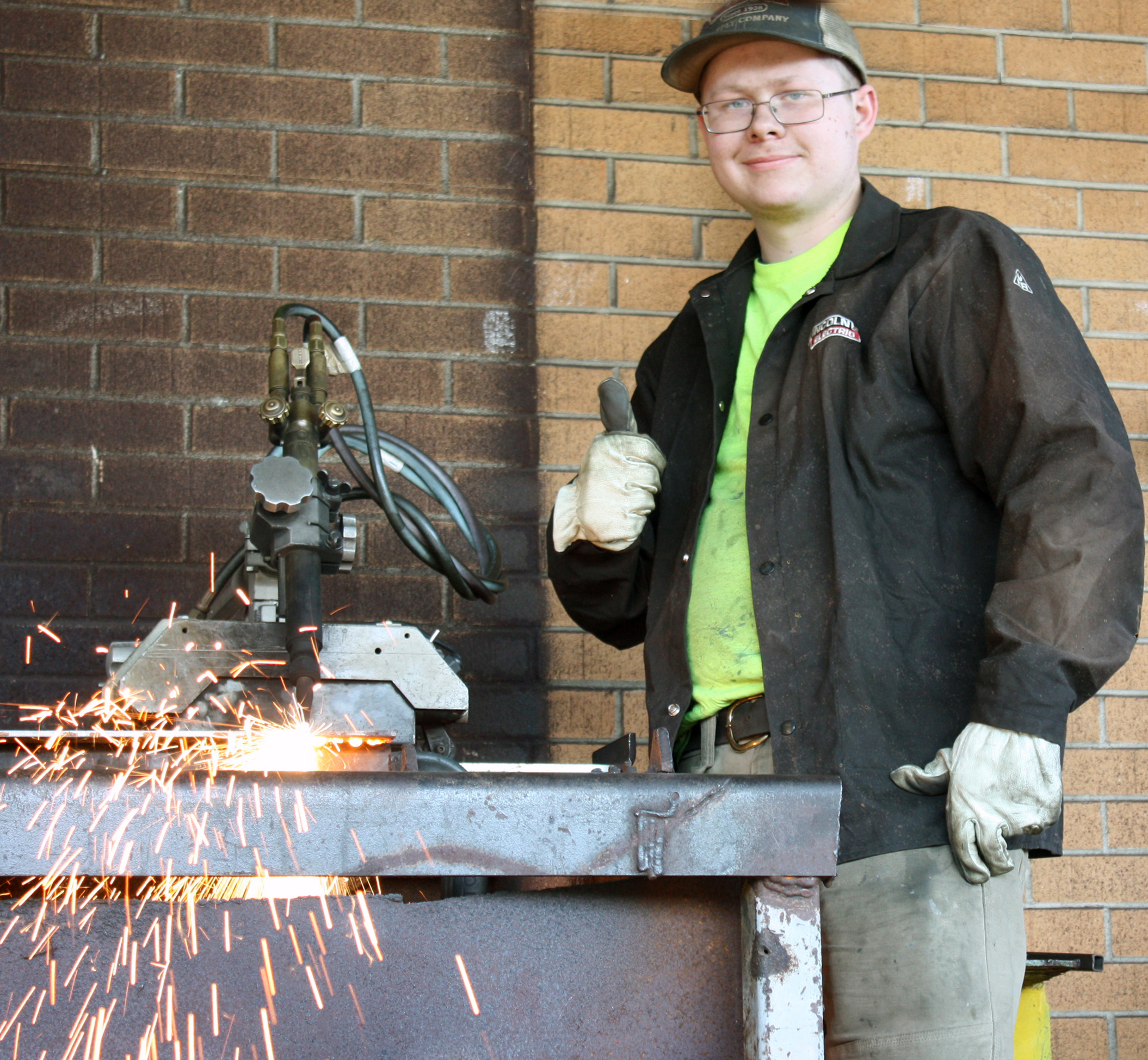 GNTC welding student Josh Foster waits as an automated guide feeds a metal plate to the track torch.