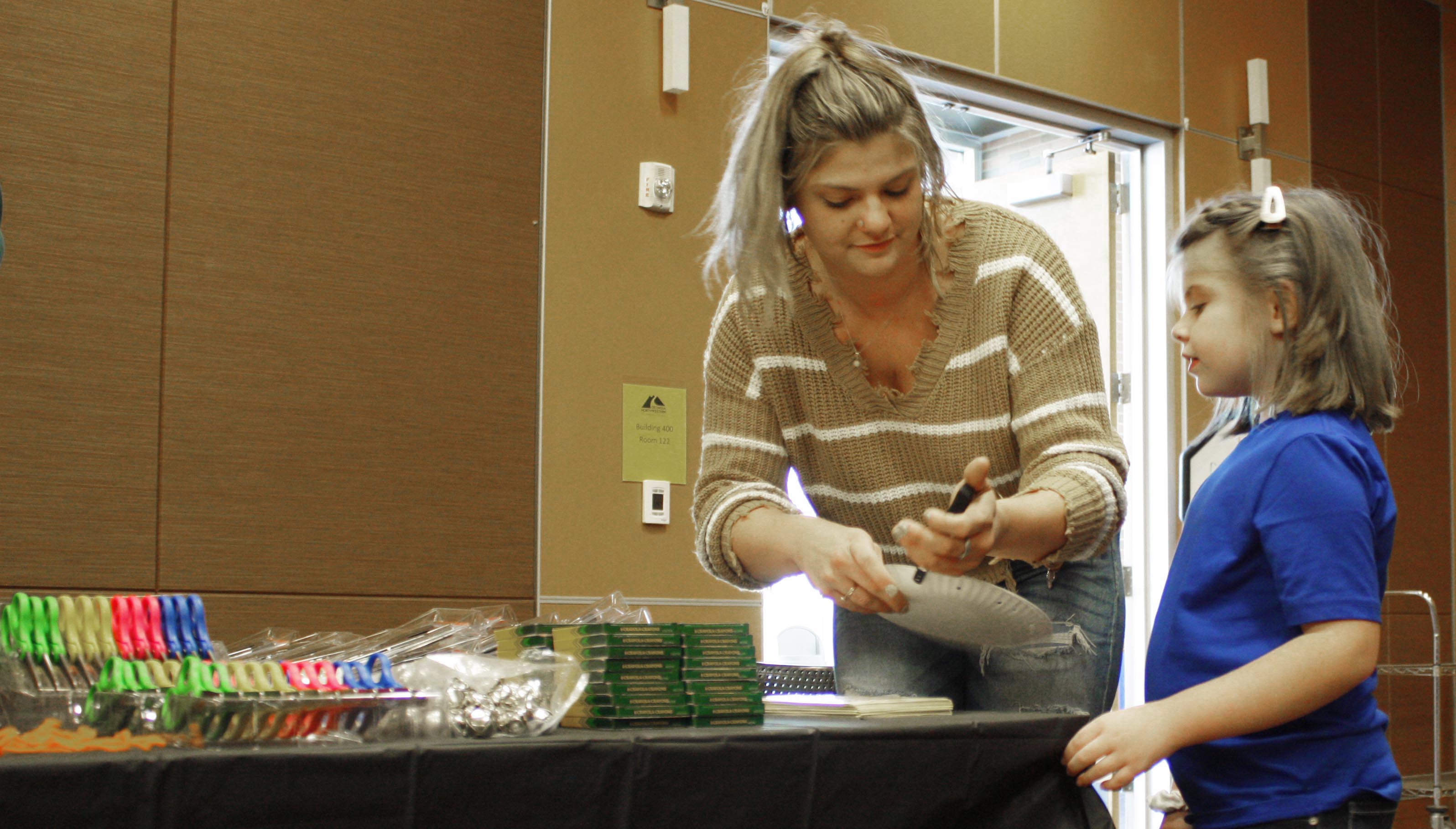 GNTC student Shanna Crocker (left) makes a tambourine with her daughter, Alaina Wheeler, during the first Kids STEM Festival held in October at the Gordon County Campus in Calhoun.