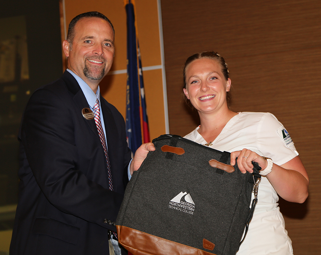 Kimberlee Hall (right) of Gordon County was presented with a tote bag by Stuart Phillips (left), interim president of GNTC, during GNTC’s Student Recognition Reception. Hall won the gold medal in Practical Nursing at SkillsUSA Georgia and will compete in the national SkillsUSA competition.
