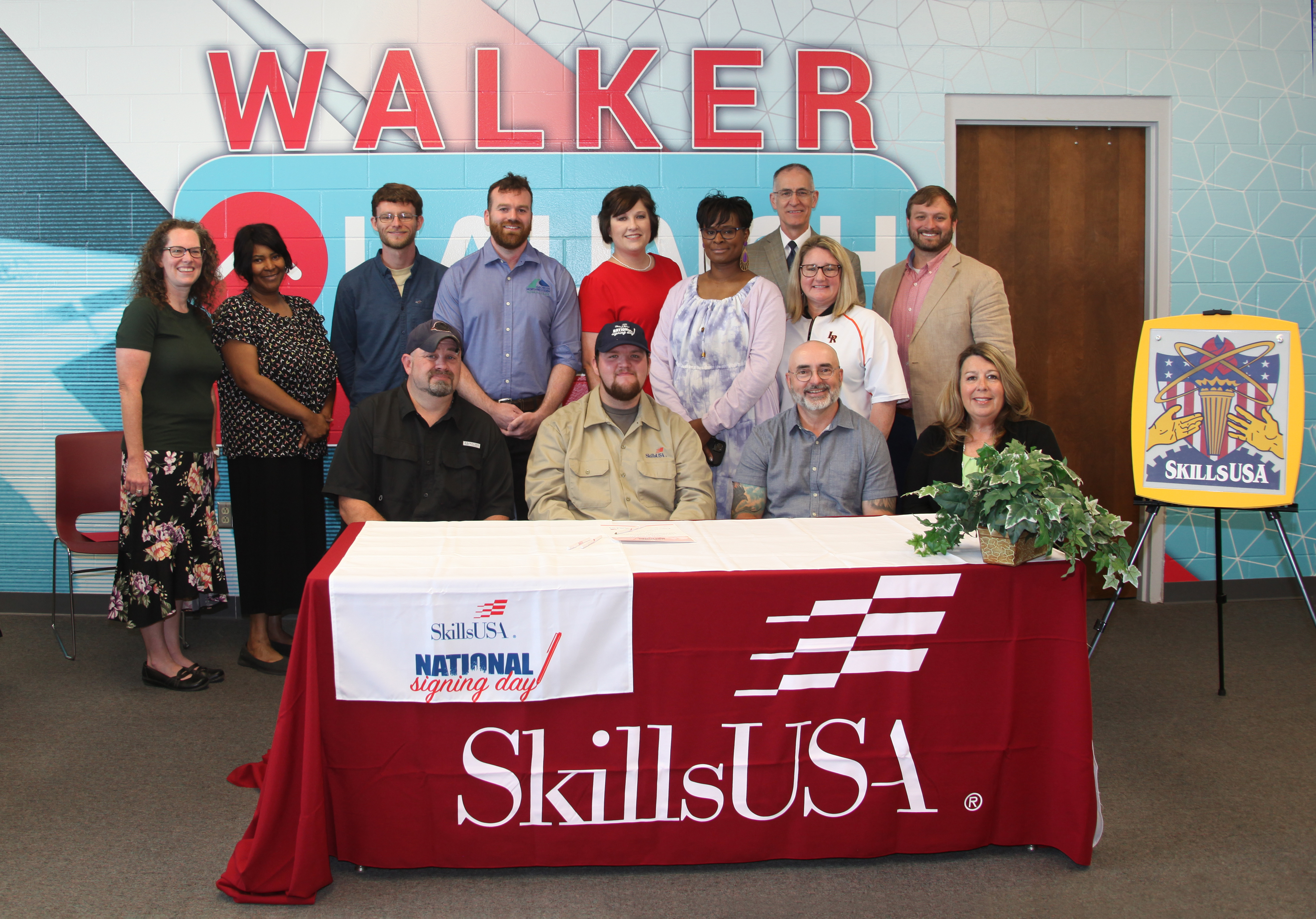 Garrett Rollins (seated, second from left) is surrounded by those who attended his SkillsUSA National Signing Day ceremony, May 5, at GNTC’s Walker County Campus. Also pictured (from left, seated) are his father, Donny Rollins; Mark Collins, Metro Boiler Tube; and Teresa Phillips, Metro Boiler Tube; (from left, standing) Julie Portwood, coordinator of Secondary Instruction and Walker LAUNCH, Walker County Schools;  Deidrienne Gross, Walker LAUNCH instructor; Tayler Davidson, instructor of Welding and Joining Technology, GNTC; Jeremiah Cooper, program director and instructor of Welding and Joining Technology, GNTC; Sarah Jenkins, SkillsUSA advisor; Lugenia Suttles, assistant principal, LaFayette High School; Damon Raines, superintendent, Walker County Schools; Maggie Stultz, principal, LaFayette High School; and Justin Carruth, coordinator of Secondary Curriculum and Career, Technical and Agricultural Education, Walker County Schools.