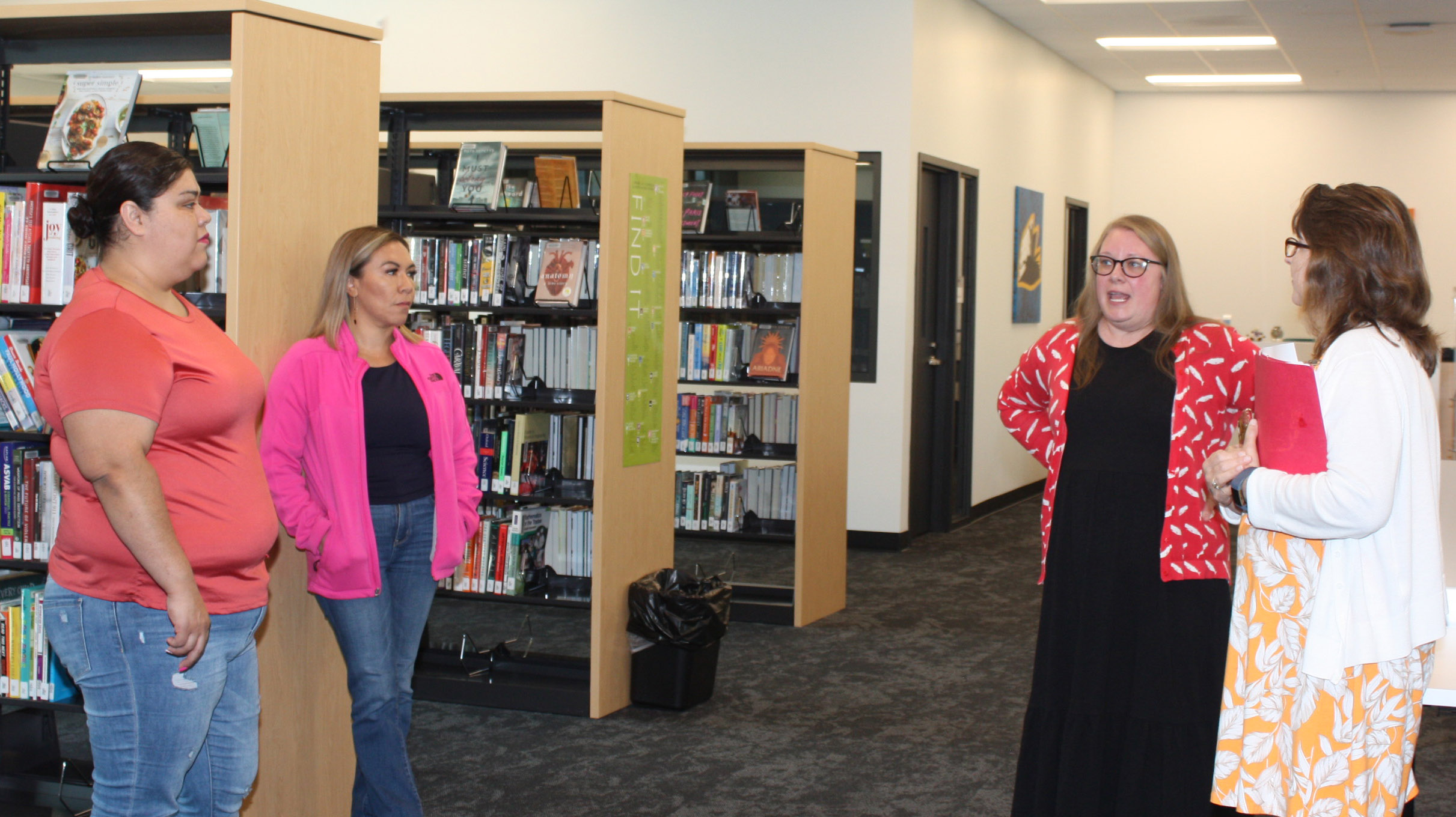 Adult Education students (from left) Jolene Monzon and Carolina Otis listen as Julie Norman, GNTC Whitfield Murray Campus Library coordinator, and Regina Casteel, Adult Education career specialist, explain resources available through the library.
