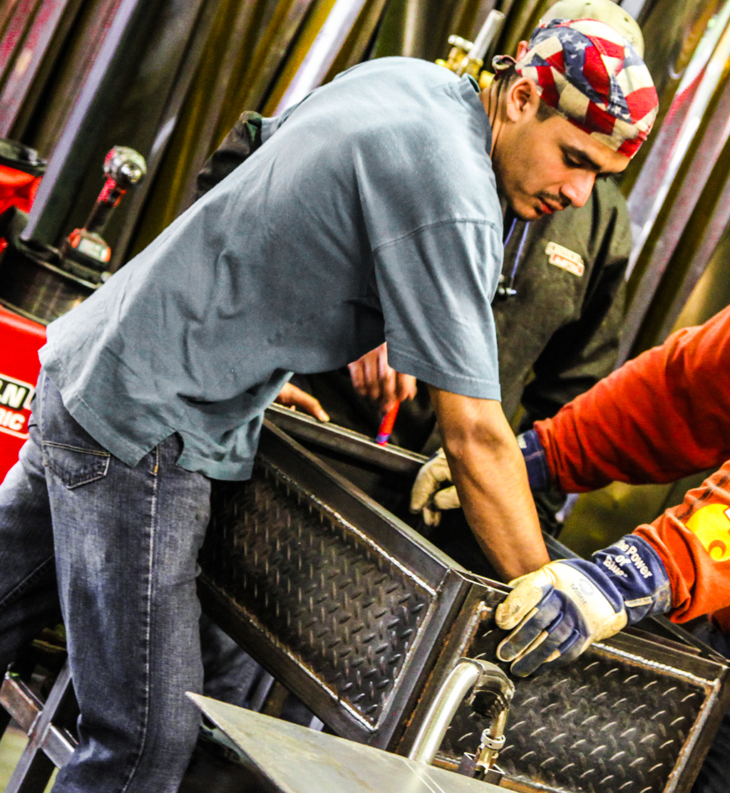 Whitfield Murray Campus welding technology student Daniel Lopez of Dalton dons his American Flag bandana as he takes a look at a project being completed in the GNTC Welding Technology lab. Lopez is part of a three-person welding fabrication team which has qualified to compete against some of the best young welders in the nation this summer.