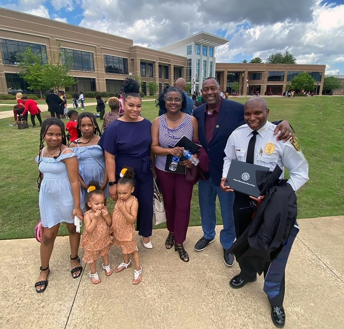 Family members of Marcus Hill (right) congratulate him at his graduation on May 6 from Atlanta Metropolitan State College with his bachelor’s degree in Criminal Justice. Also pictured (from left, front) are daughters Oakley and Ivy Hill; (from left, back) daughters Shanelle and Danielle Hill, wife Kieriea Hill, godmother Peggy Jordan and godfather Dr. C.L. Jordan, president of Carver Bible College. Not pictured are daughters Armani and Amir Hill.