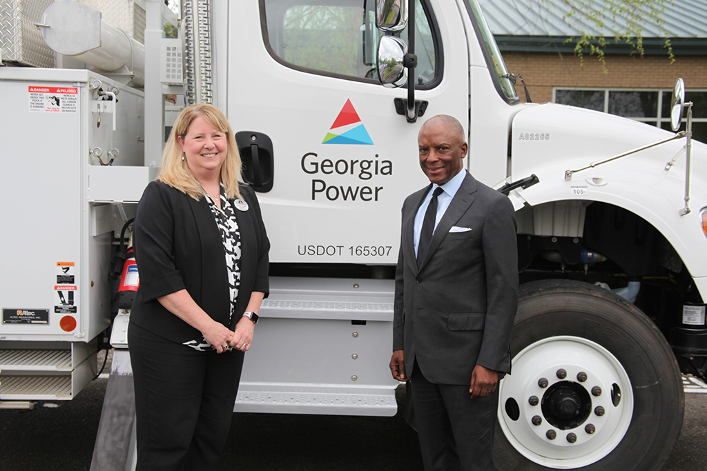 Dr. Heidi Popham, left, president of Georgia Northwestern Technical College (GNTC), and Chris Womack, chairman, president and CEO for Georgia Power, pose in front of a Georgia Power bucket truck.