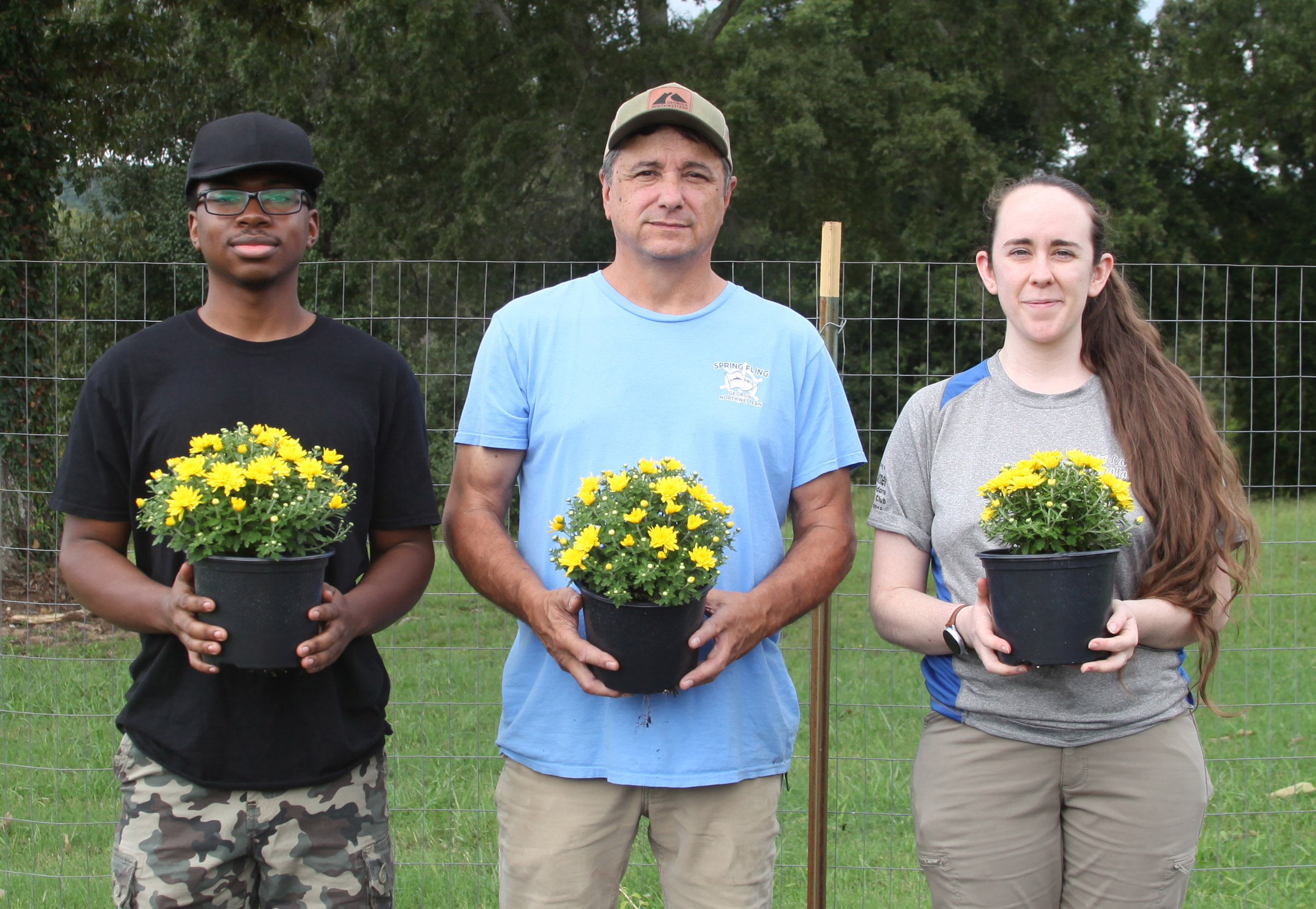 Nick Barton, director of GNTC’s Horticulture program (center), and Horticulture students Timothy Roberts (left) and Amber Broome prepare for the Fall Mum Sale.