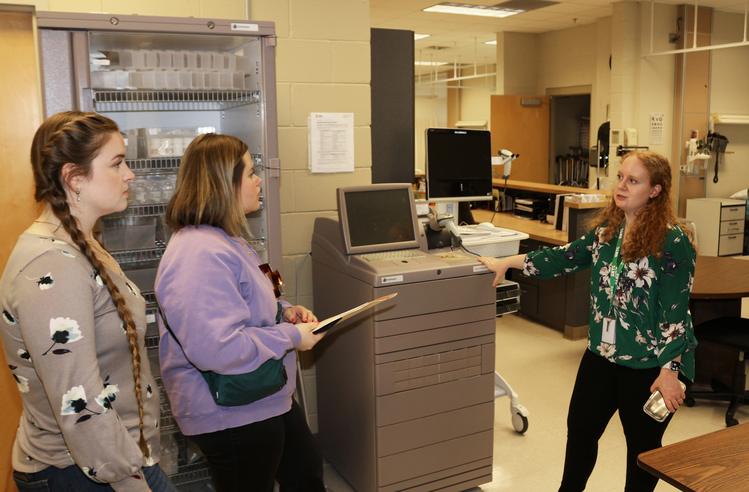 Lauren Vosika, GNTC Practical Nursing instructor (right), explains to Audrey Powell (left) and Maleah Smith how the Pyxsis MedStation dispenses medication for patients.