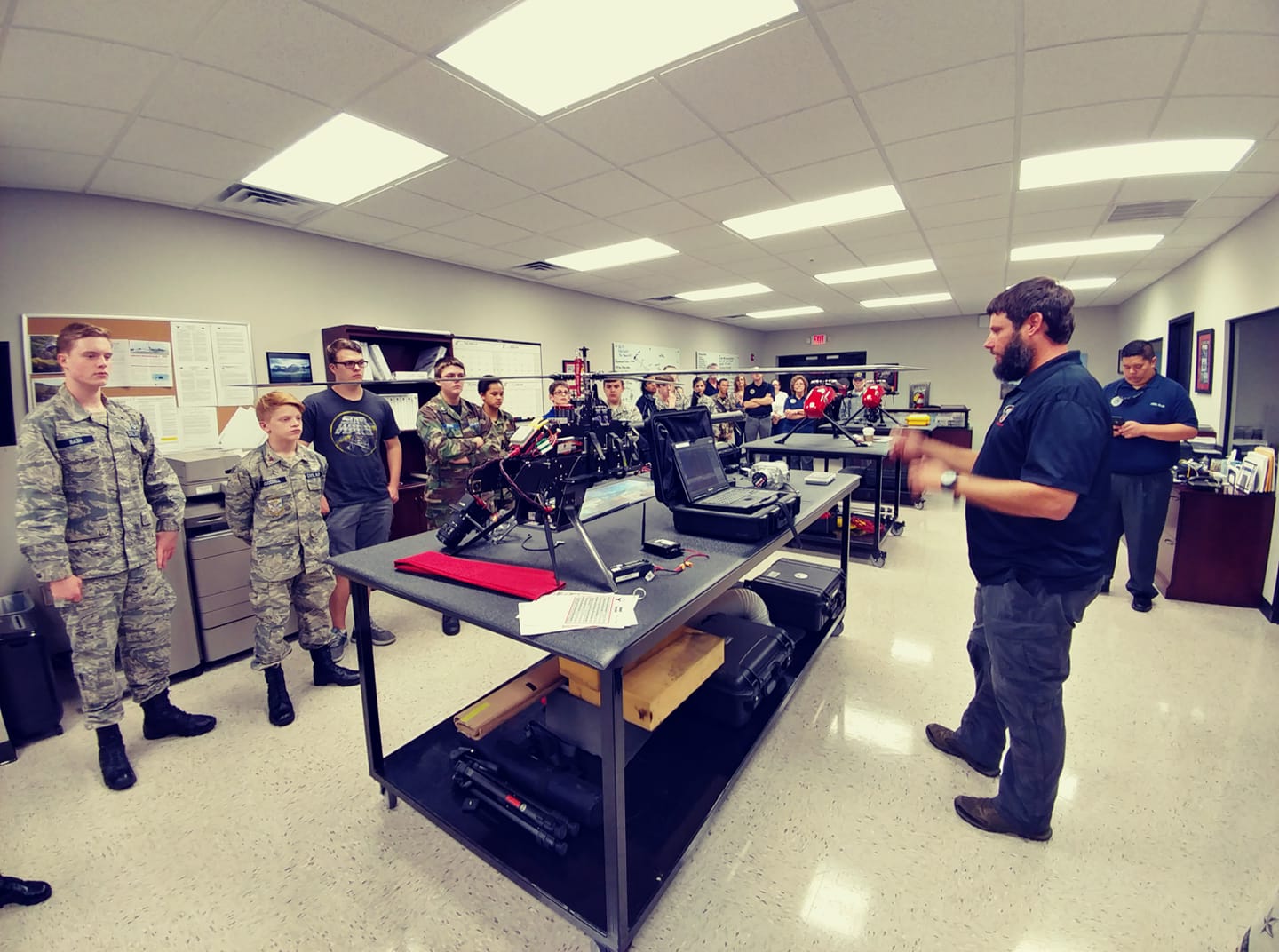 GNTC alum Patrick Hayes (right), UAS, Maintenance Lead for Phoenix Air Unmanned, demonstrates a Pulse Aerospace Vapor 55 to a student group.