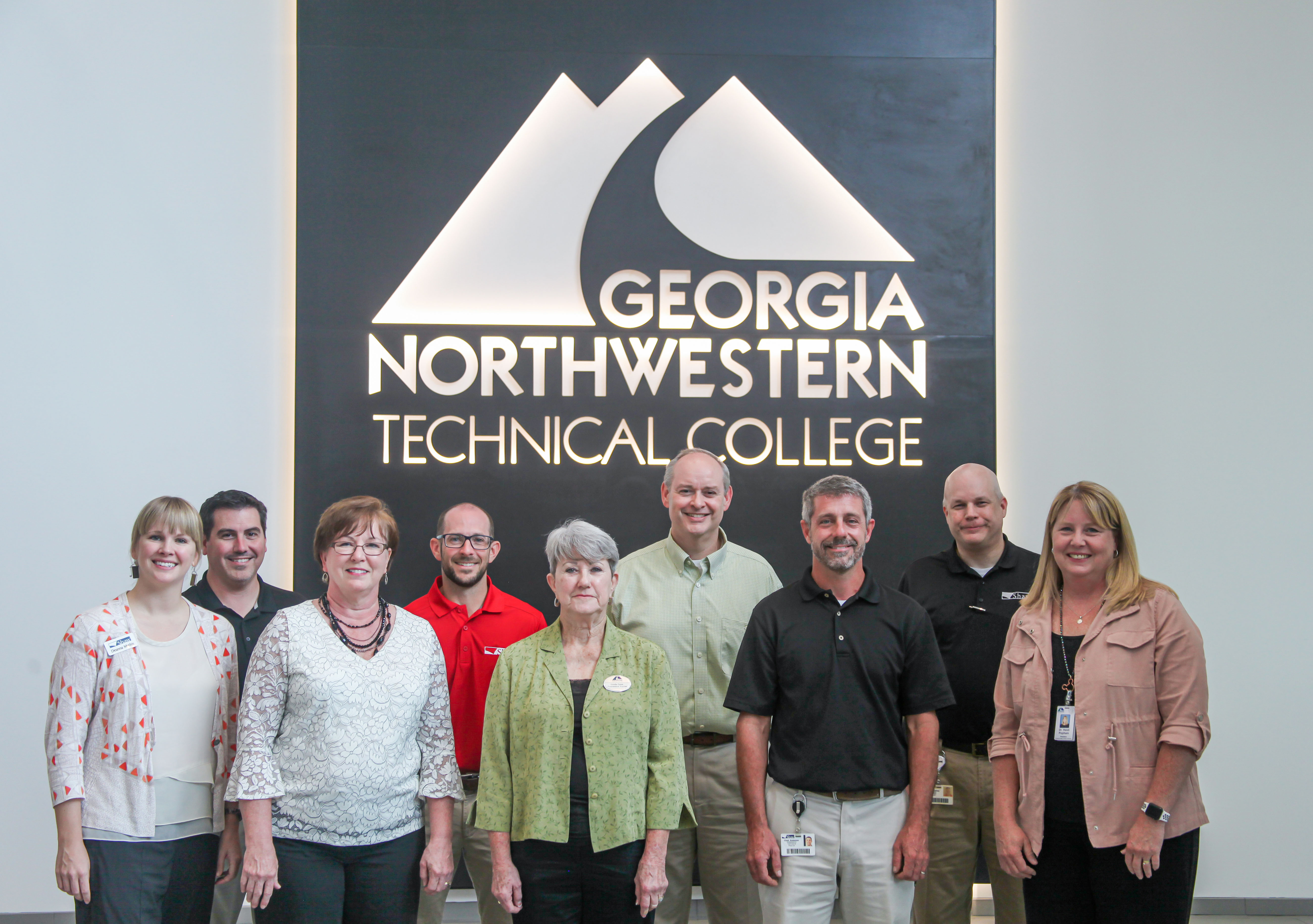 Front row, from left to right: Deanna Mathis, Shaw director of Corporate Outreach; Emily Lightsey, Shaw plant manager; Linda Case, GNTC Board of Trustees Vice Chair; Chad Anderson, Shaw director of Collaborative Innovative Manufacturing (CIM); and GNTC President Dr. Heidi Popham.

Back row, from left to right: Darrell Huggins, GNTC program director and instructor of Automation Engineering Technology; Colin Drafts, Shaw plant manager; Winston Massengale, Shaw vice president of Automation and Engineering; and Brian Cooksey, Shaw director of Workforce Development. 
