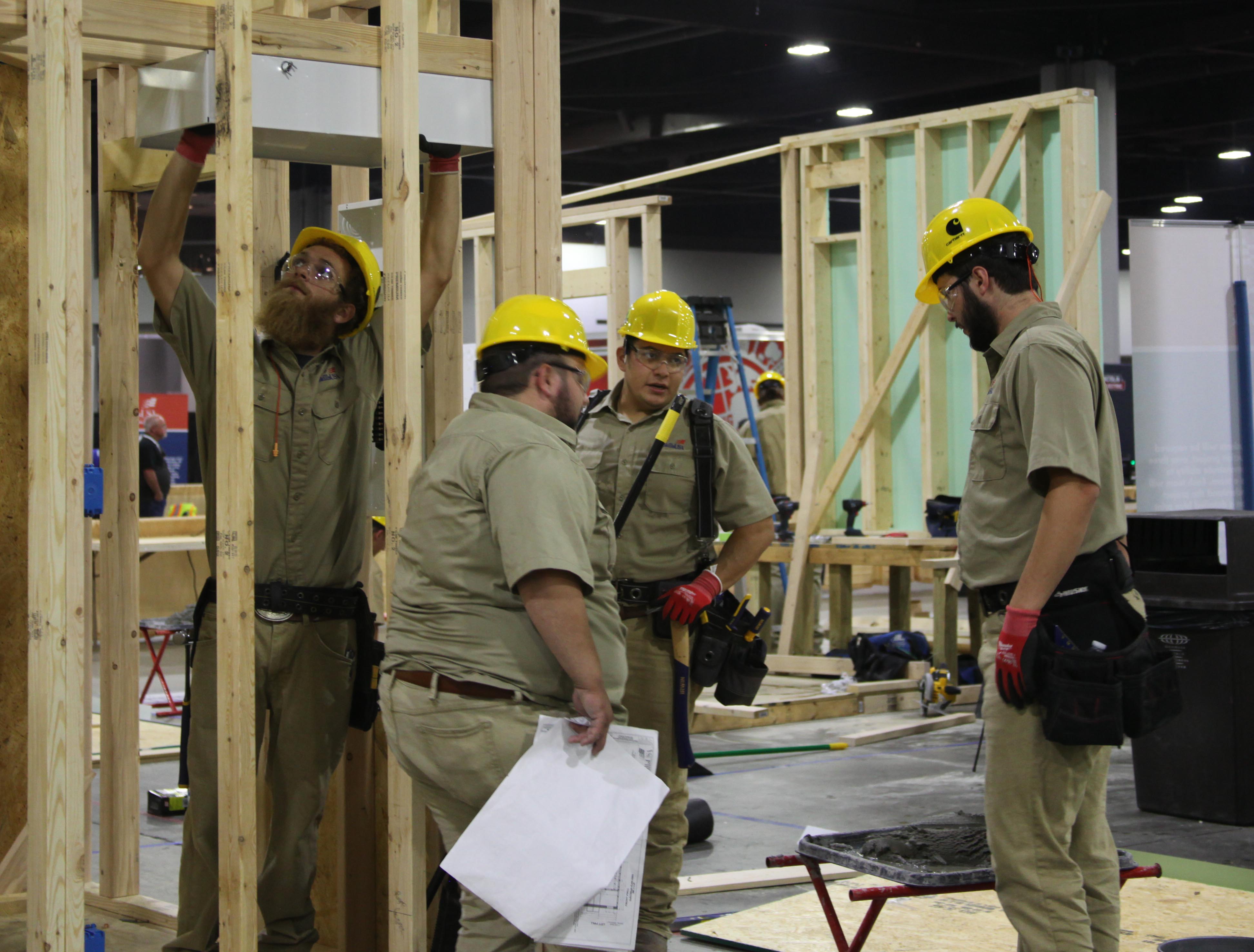 (From left) Trey Posey, Tyler West, Leonardo Garcia and Finn White assess their progress on the construction project at the SkillsUSA National Leadership and Skills Conference.