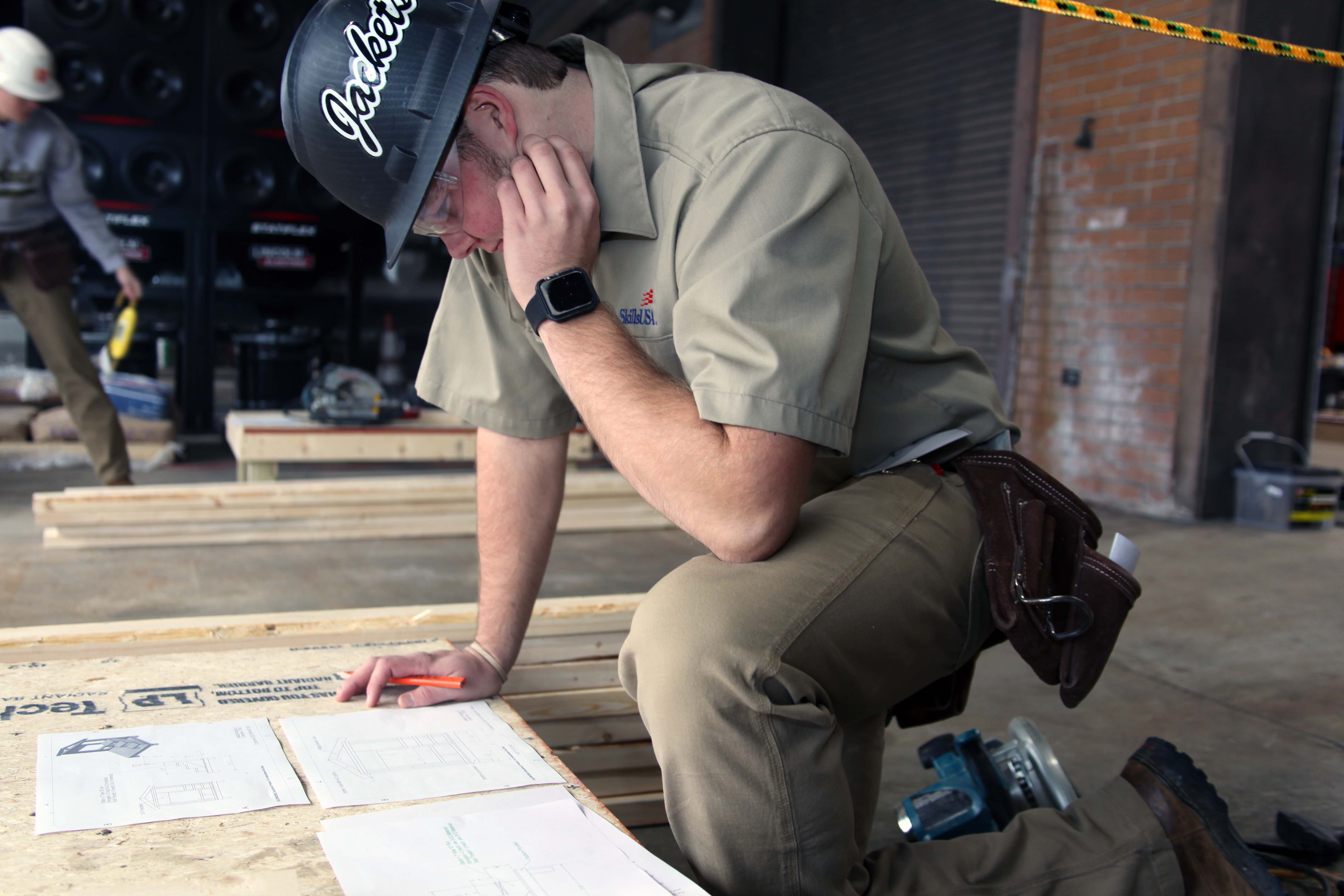 Will Holden of Calhoun High School studies the blueprints of a wall frame with a window, stairs and a railing he had to build during the SkillsUSA Region 1 competition on Friday, Dec. 6.   