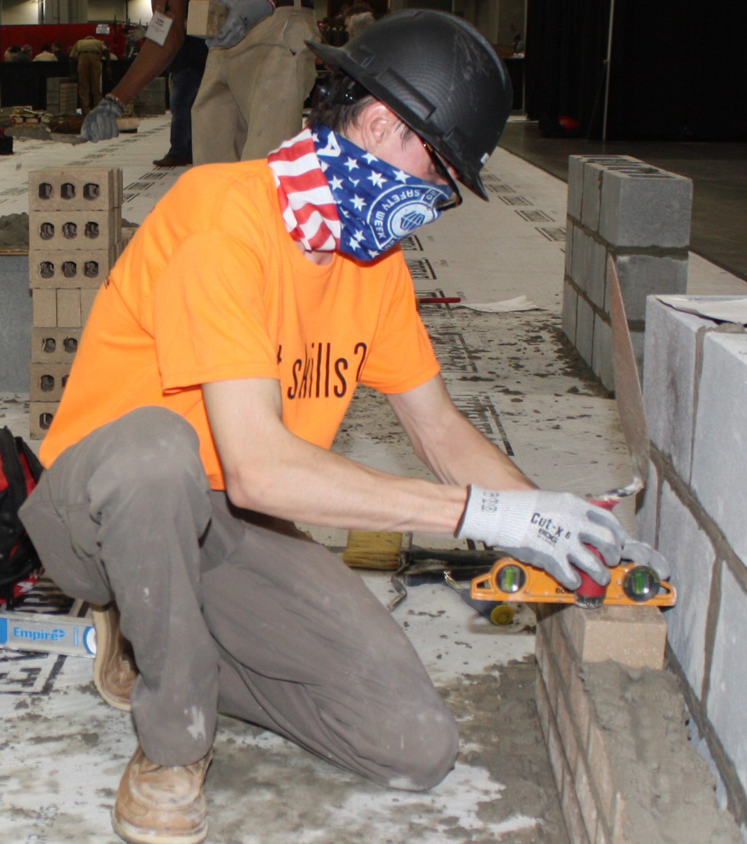 Bryson Thurman checks that the brick wall he is building is level in the Masonry competition.