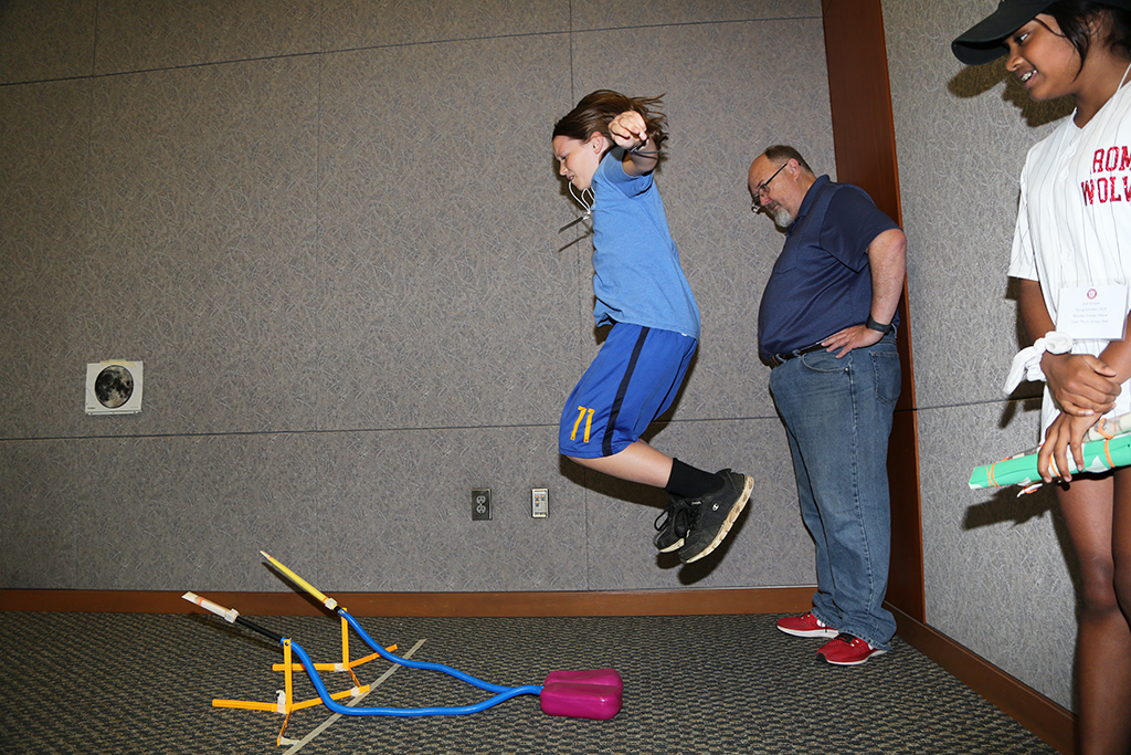 Theo Scott (left), rising eight-grader at Rome Middle School, jumps in the air to launch the rockets he built in Aerospace Engineering during the Young Scholars Program at GNTC. Also pictured is Jaya Cooper (right), rising eighth-grader at Rome Middle School, and Randy Stafford (center), Physics Teacher at Rome High School. 