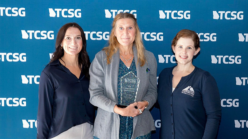 (From left) Emily Russell, E.K. West, and Ana King, pose for a photo as West holds her TCSG Student Impact Award.
