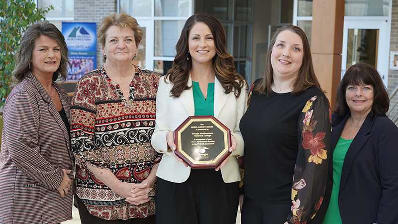 Human Resources staff display the Tier 1 award