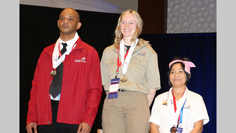 Lorianna Beech (center) receives the gold medal in Carpentry