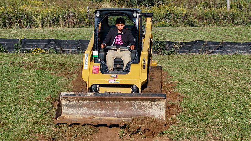 GNTC student Luis Garcia practices using a skid steer loader.