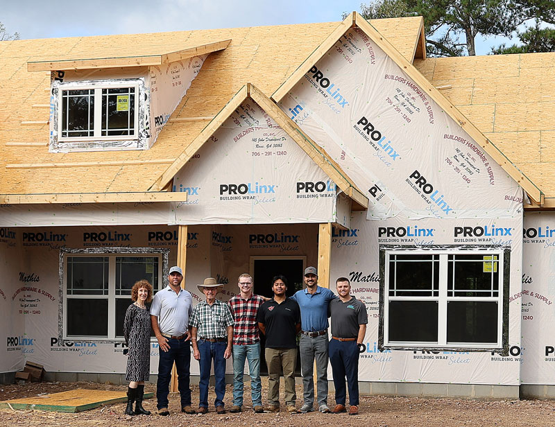 (From left) Sarah Egerer, GNTC Foundation administrator; Jessie Bannister, RHBA; Sammy Bartley, RHBA; Connor Rowell, RHBA Scholarship recipient; Yonatan Gonzalez, RHBA Scholarship recipient; Will Mathis, RHBA; and Josh Bullock, RHBA, pose for a picture in front of a construction site.