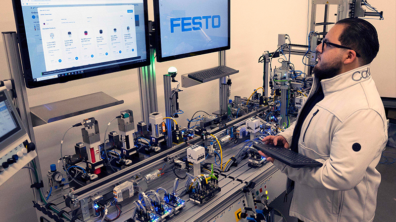 Automation Engineering - GNTC student Miguel Lopez, a Dalton resident, works on a Mechatronics trainer.