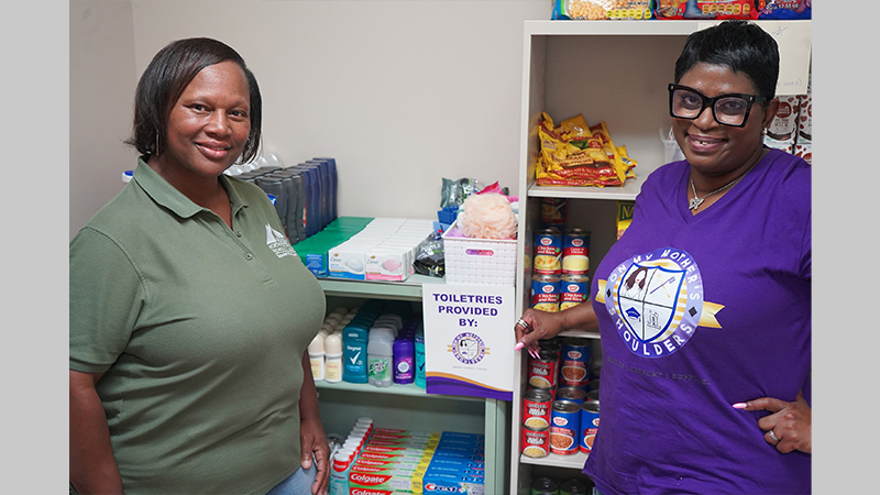 Shawn Peeks, Special Populations coordinator at GNTC (left), and Claudia Phillips, founder and chief executive officer of On My Mother’s Shoulders, pose with items the nonprofit donated to GNTC.